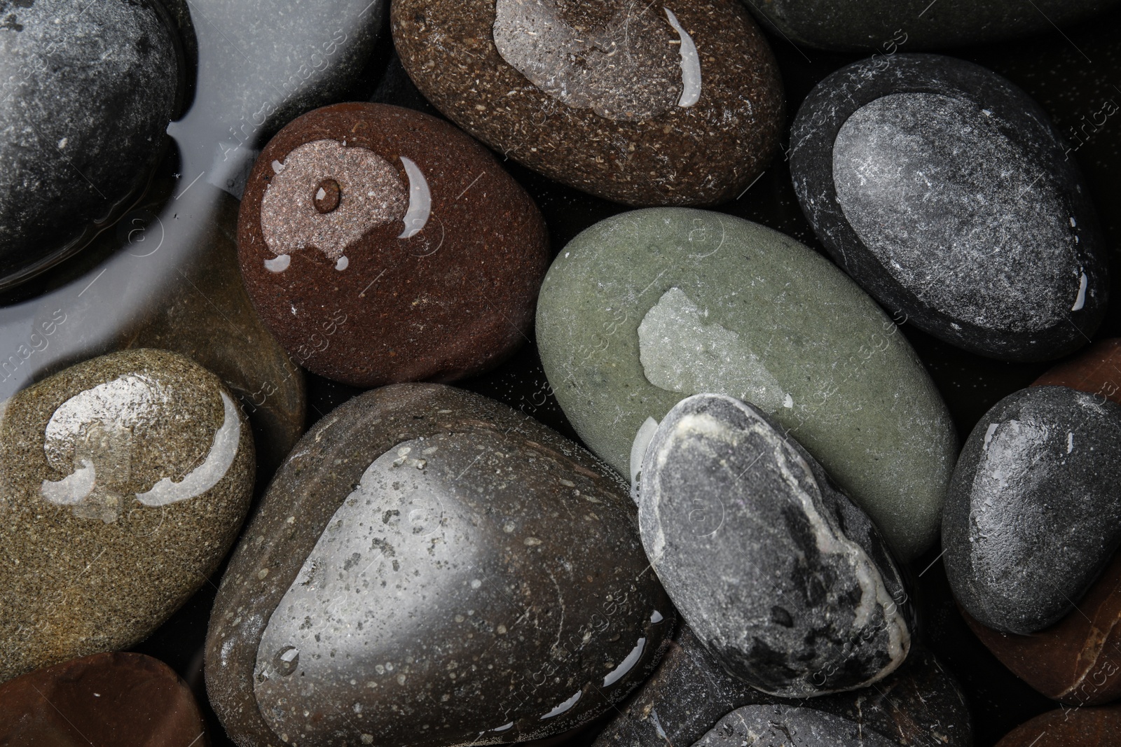 Photo of Pile of stones in water as background, top view. Zen lifestyle