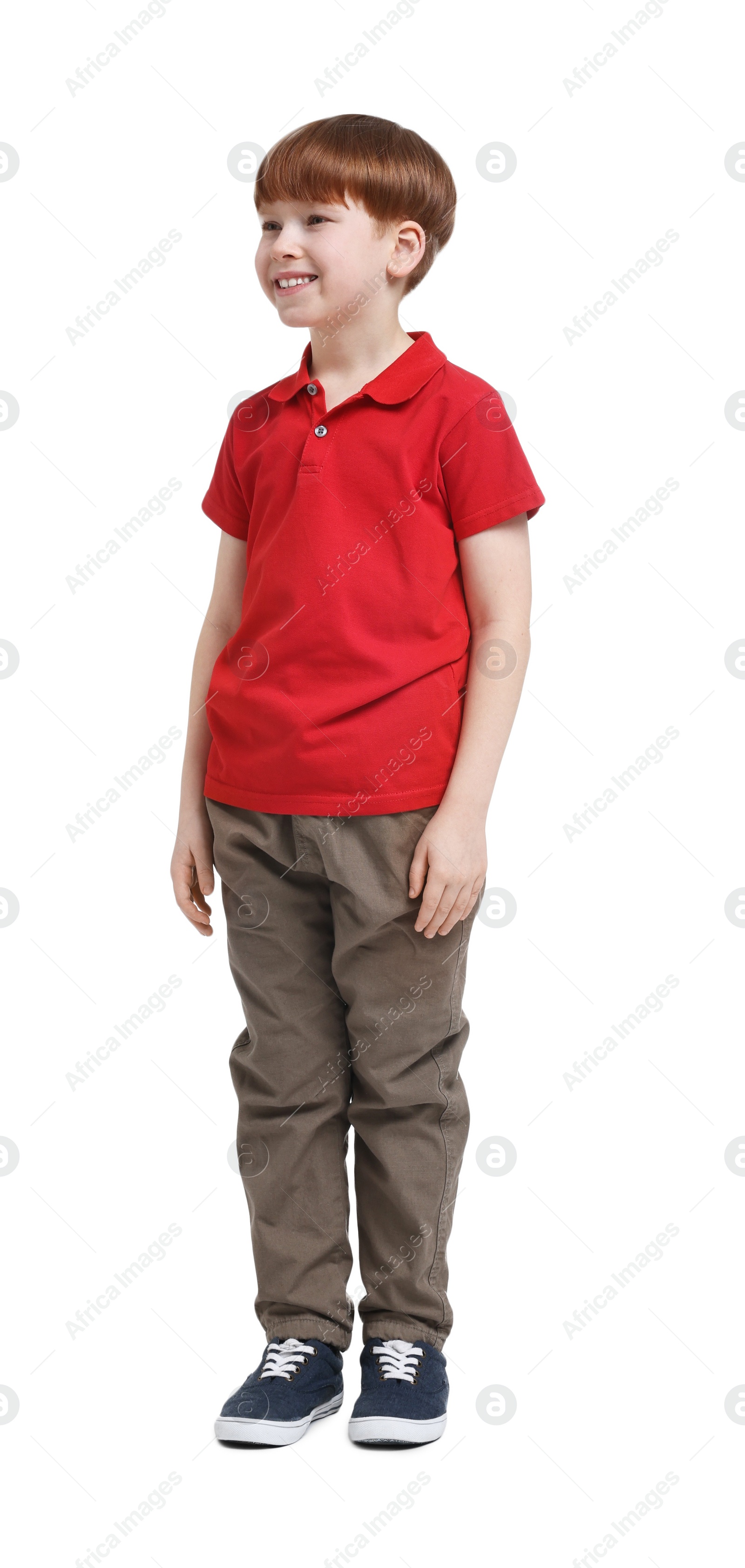 Photo of Little boy in red polo shirt and beige pants on white background