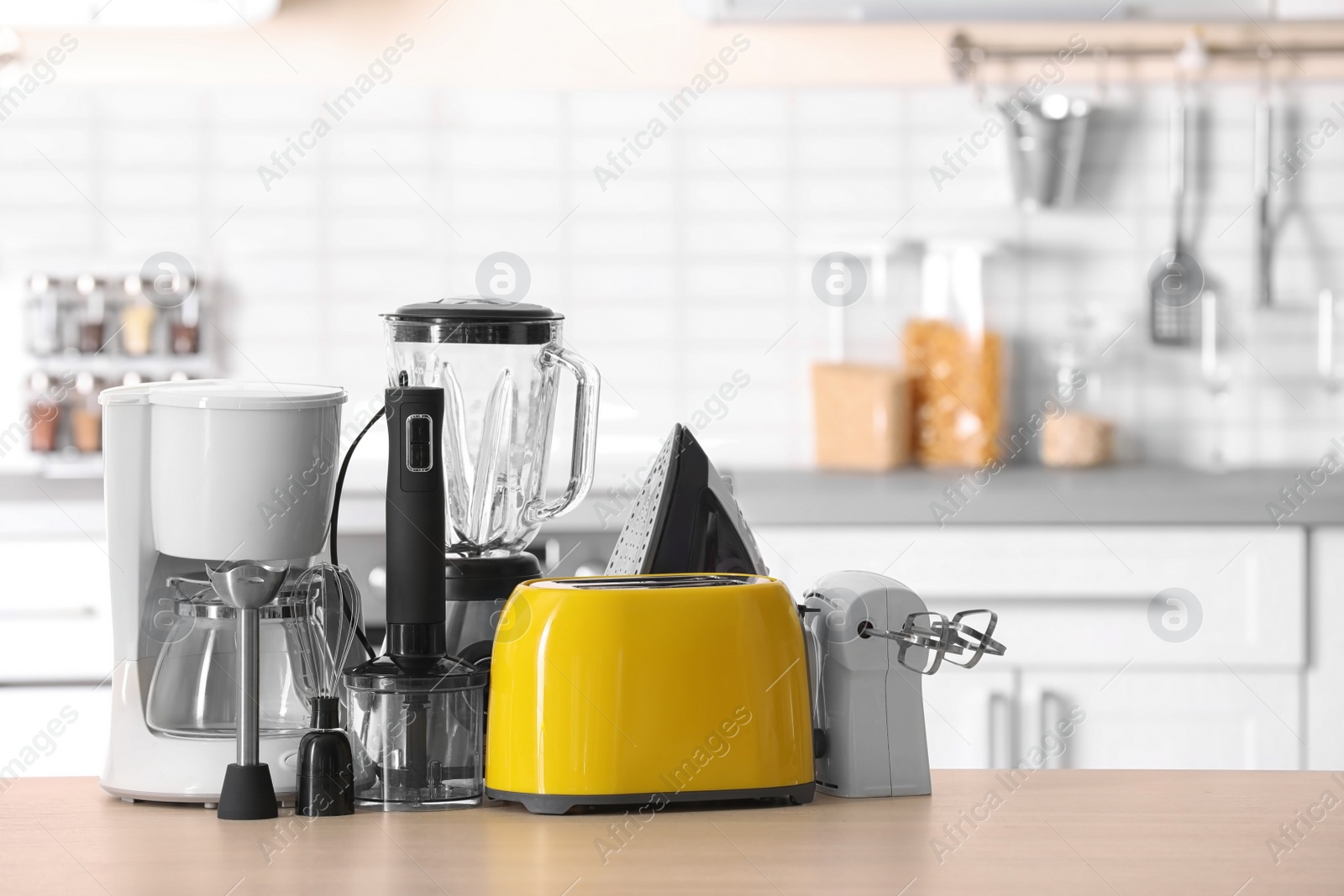 Photo of Household and kitchen appliances on table against blurred background