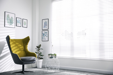 Photo of Comfortable armchair near white wall in light room