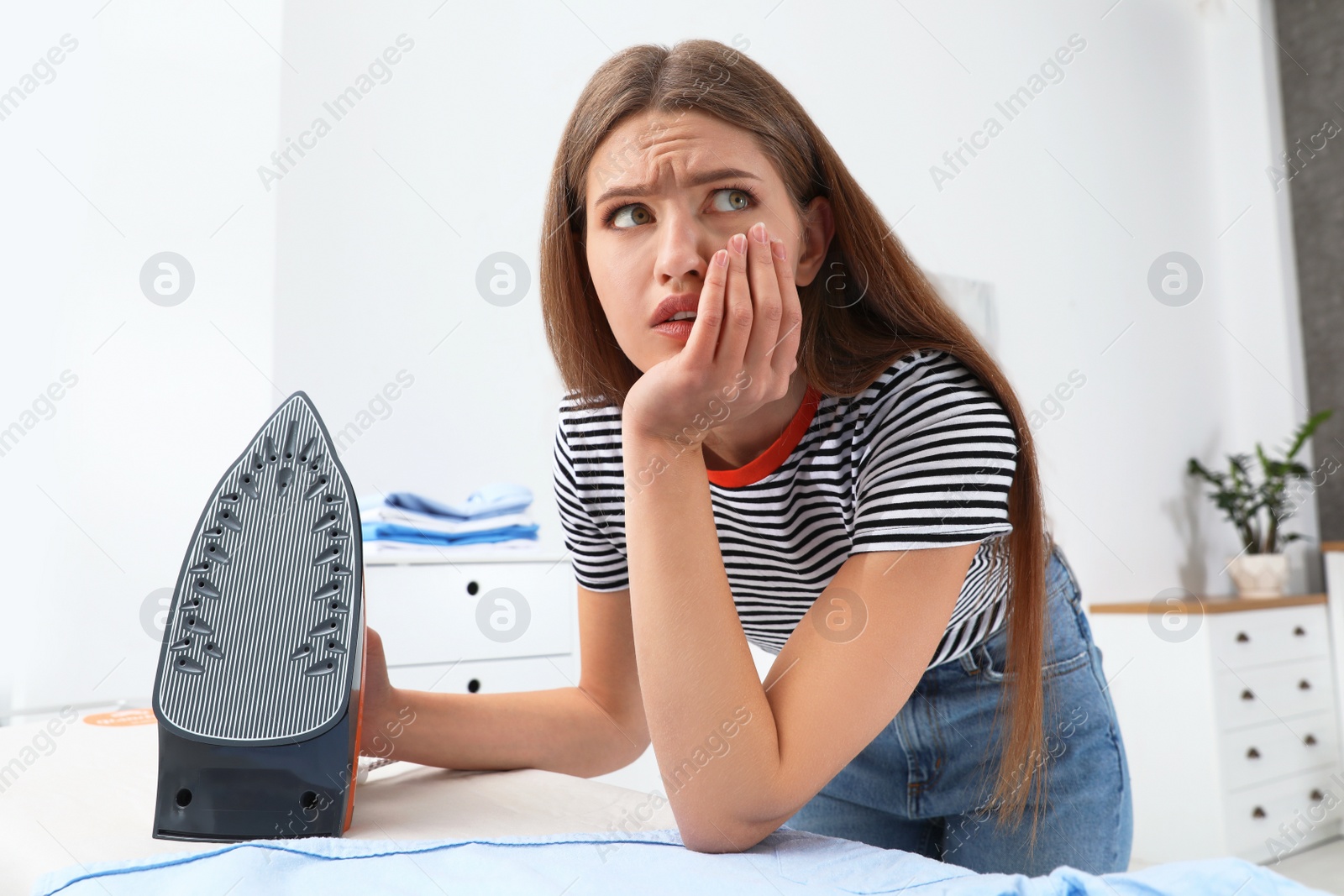 Photo of Emotional woman with modern iron at home