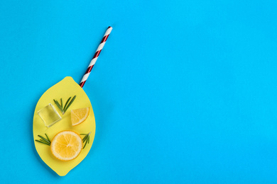 Photo of Creative lemonade layout with lemon slices on blue background, top view. Space for text