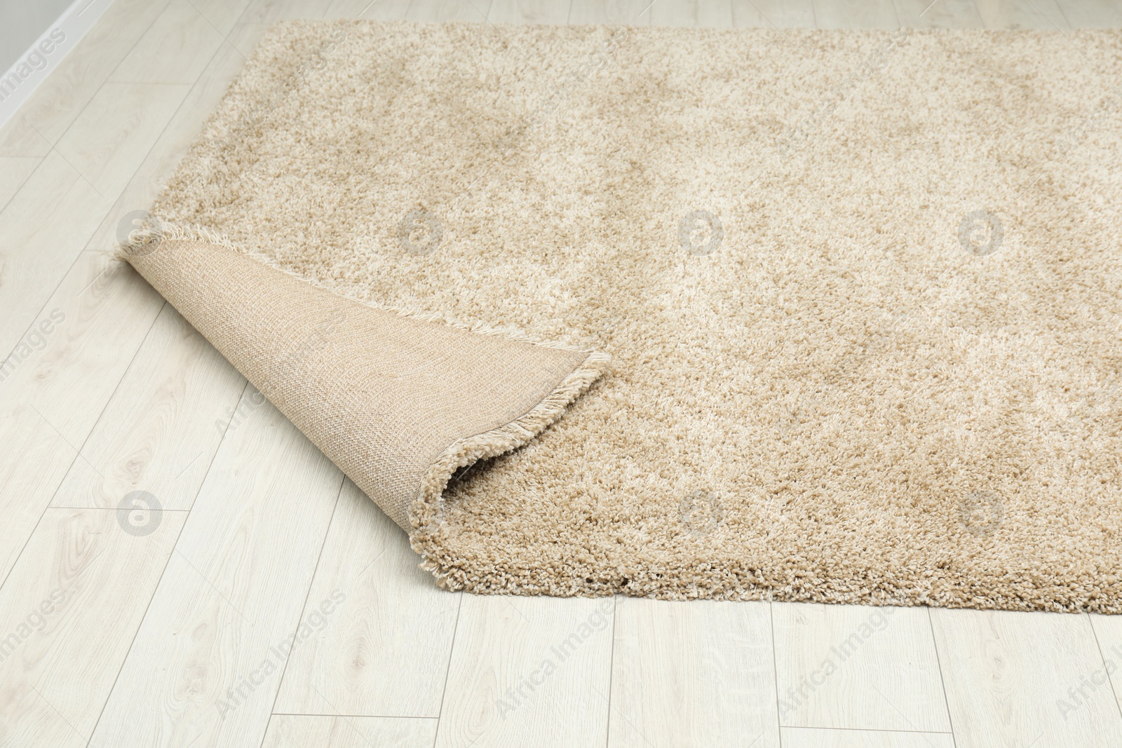 Photo of Soft beige carpet on white laminated floor indoors