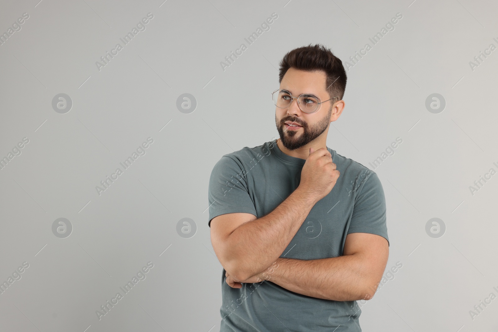 Photo of Handsome man wearing glasses on light gray background, space for text