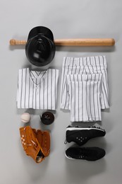 Photo of Baseball uniform and other sports equipment on white background, flat lay