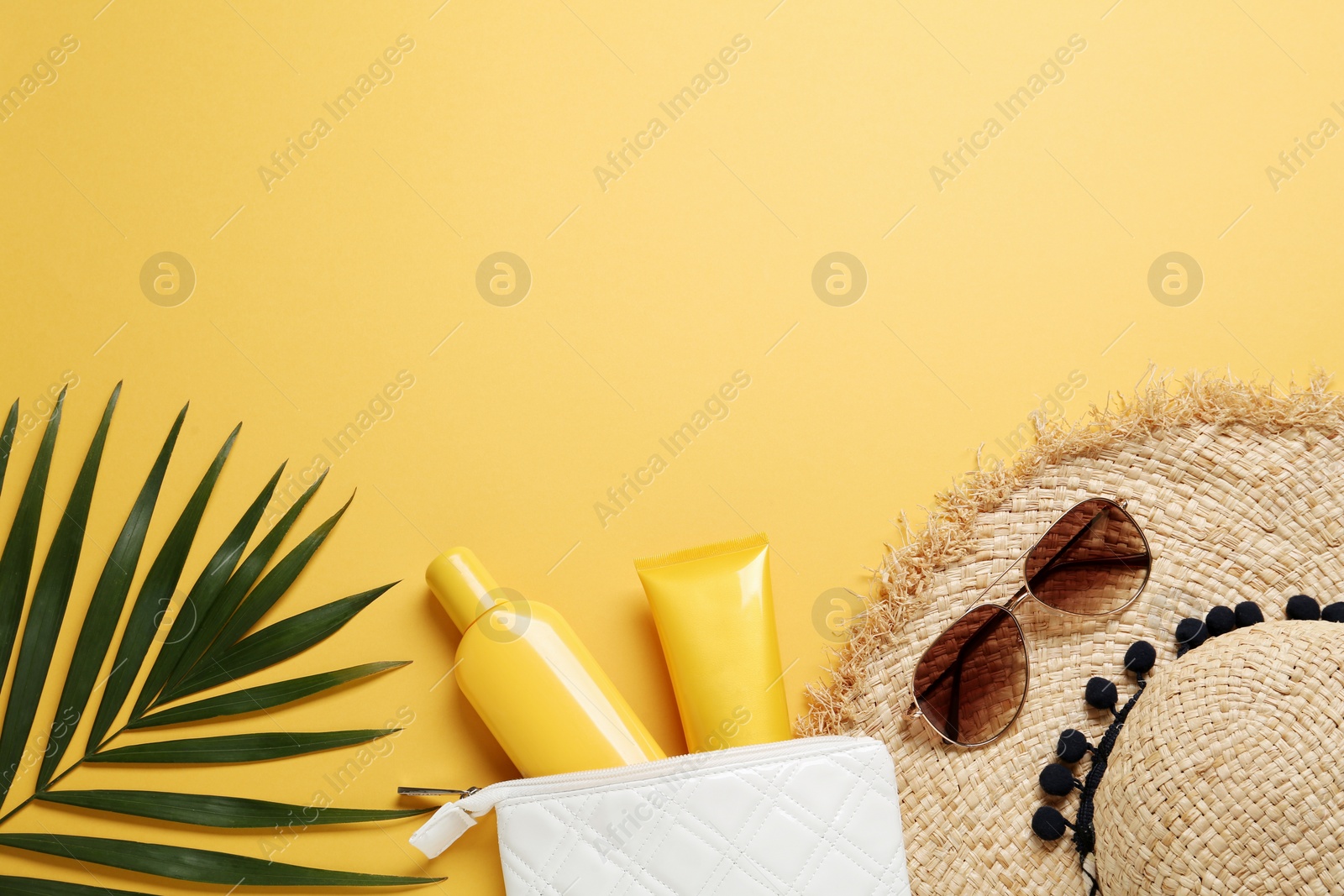 Photo of Sun protection products and beach accessories on orange background, flat lay. Space for text