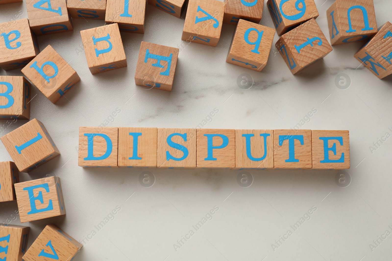 Photo of Cubes with word Dispute on white marble table, flat lay