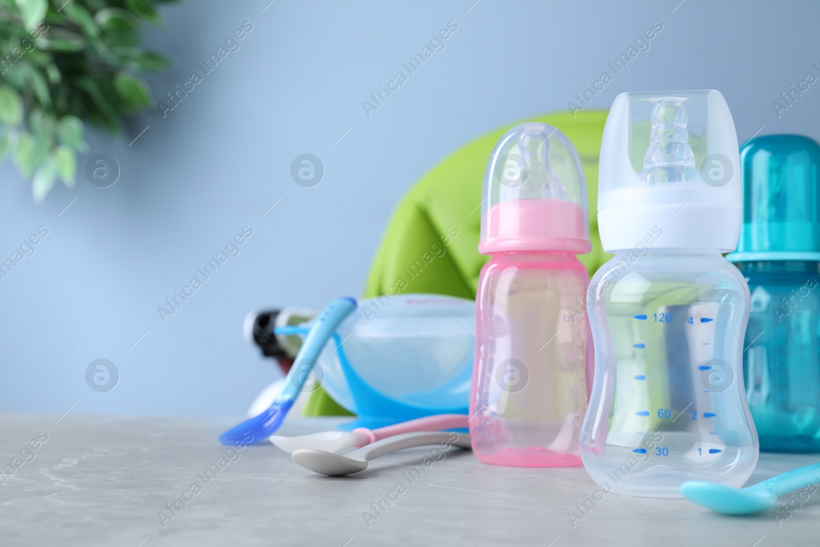 Photo of Bright child's dishware on grey table indoors. Space for text