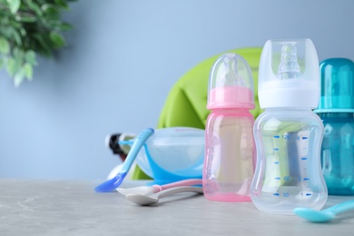 Photo of Bright child's dishware on grey table indoors. Space for text