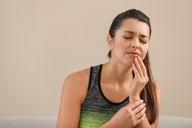 Photo of Young woman with sensitive teeth on color background. Space for text