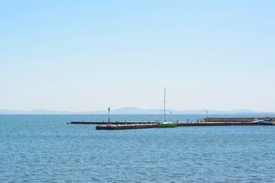 Photo of Beautiful seascape with concrete pier and moored boat on sunny day