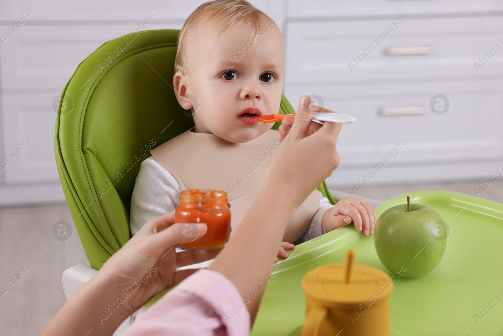 Photo of Mother feeding her cute little baby with healthy food at home