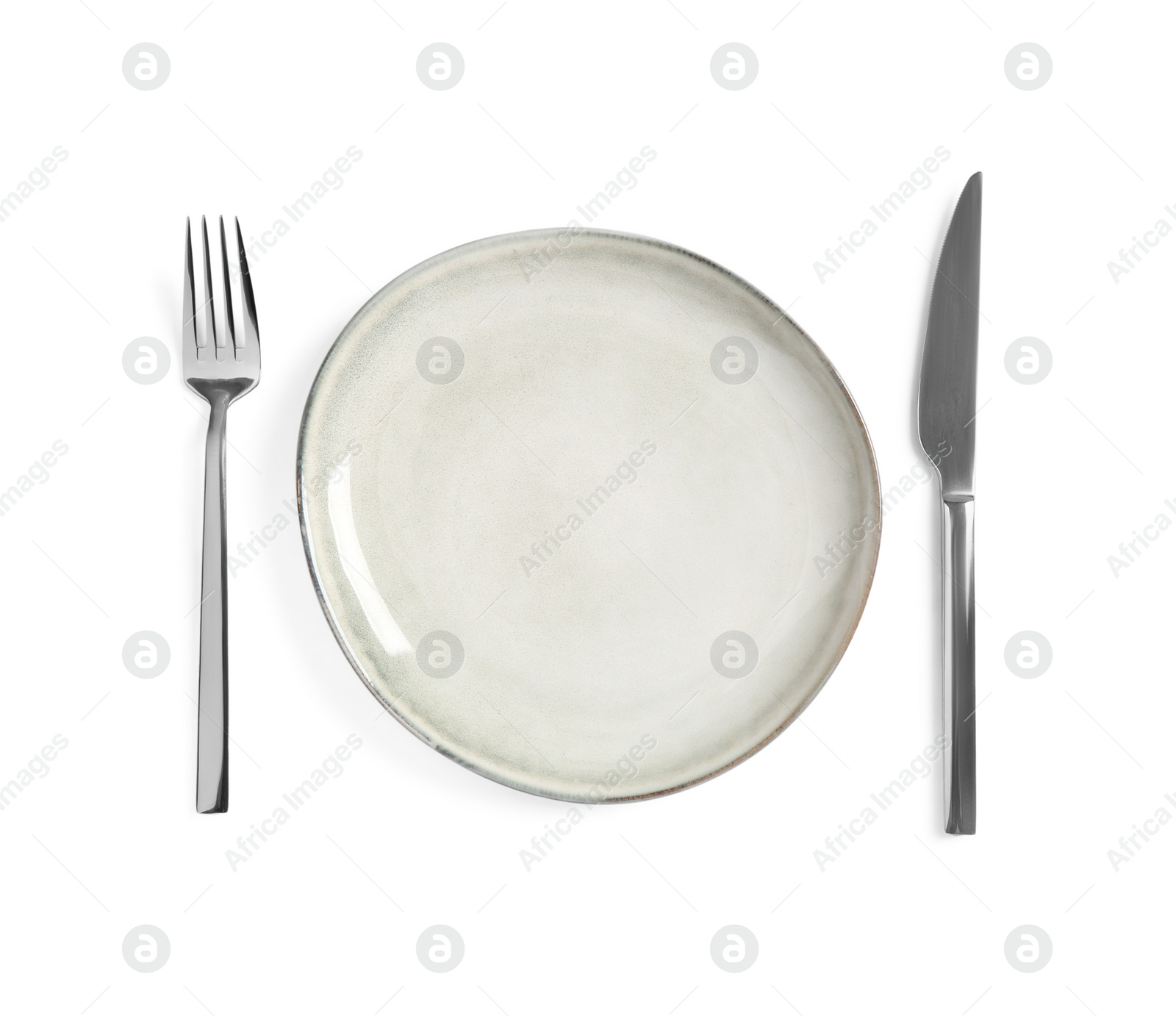 Photo of Clean plate and shiny cutlery on white background, top view