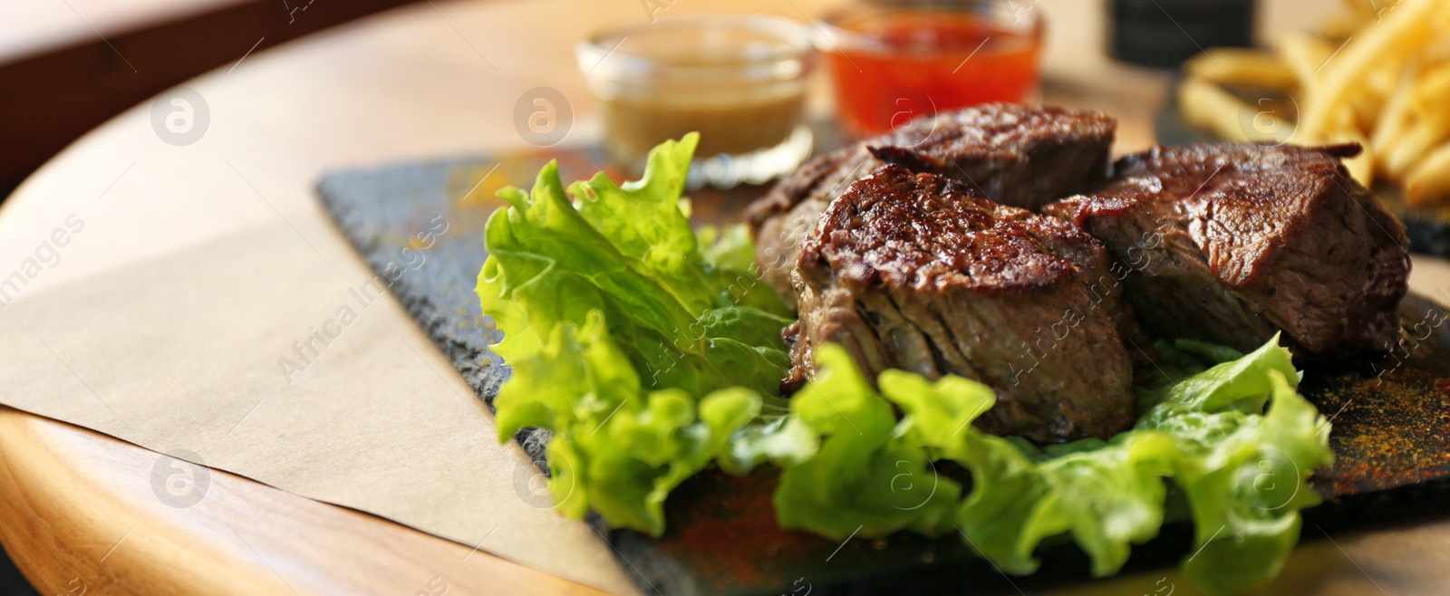 Image of Tasty pieces of shish kebab served on slate plate in cafe. Banner design