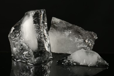 Photo of Pieces of clear ice on black mirror surface