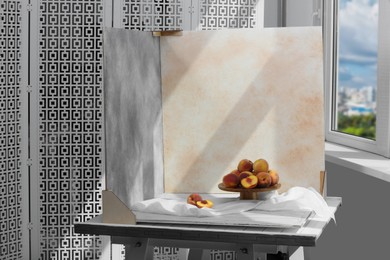 Photo of Stand with juicy peaches and double-sided backdrops in photo studio