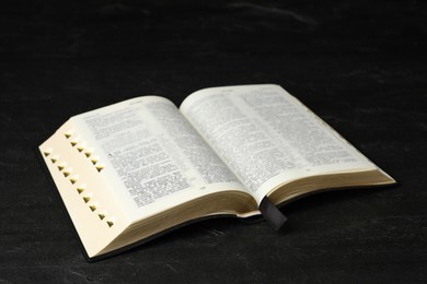 Photo of Open Bible on black table. Christian religious book
