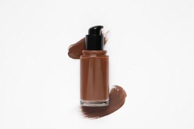 Liquid foundation and swatches on white background, top view