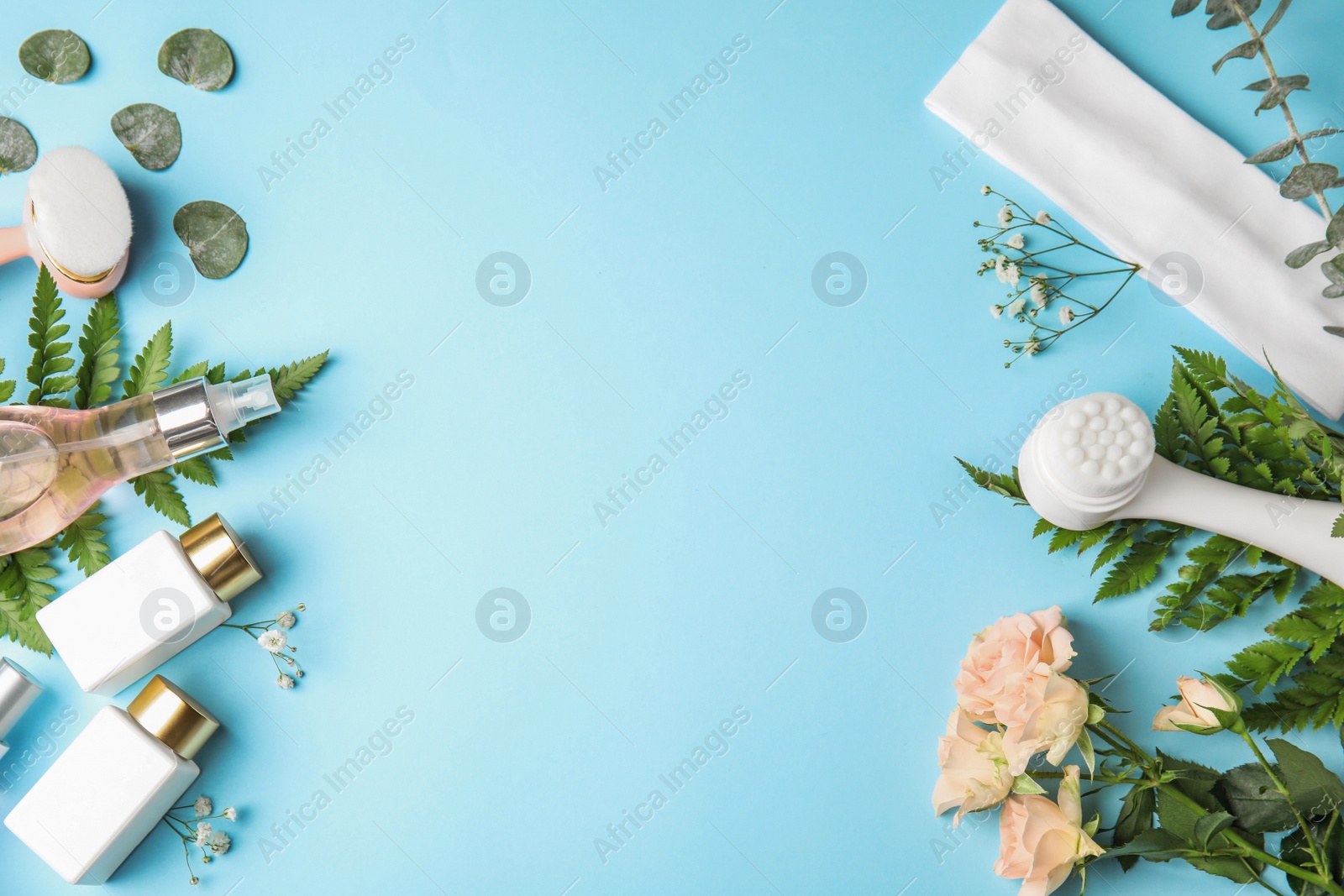 Photo of Flat lay composition with face cleansing brushes on light blue background, space for text. Cosmetic accessories