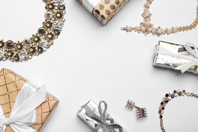 Beautiful jewelry and gift boxes on light background, flat lay. Space for text