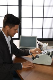 Photo of Man using banknote counter at wooden table indoors