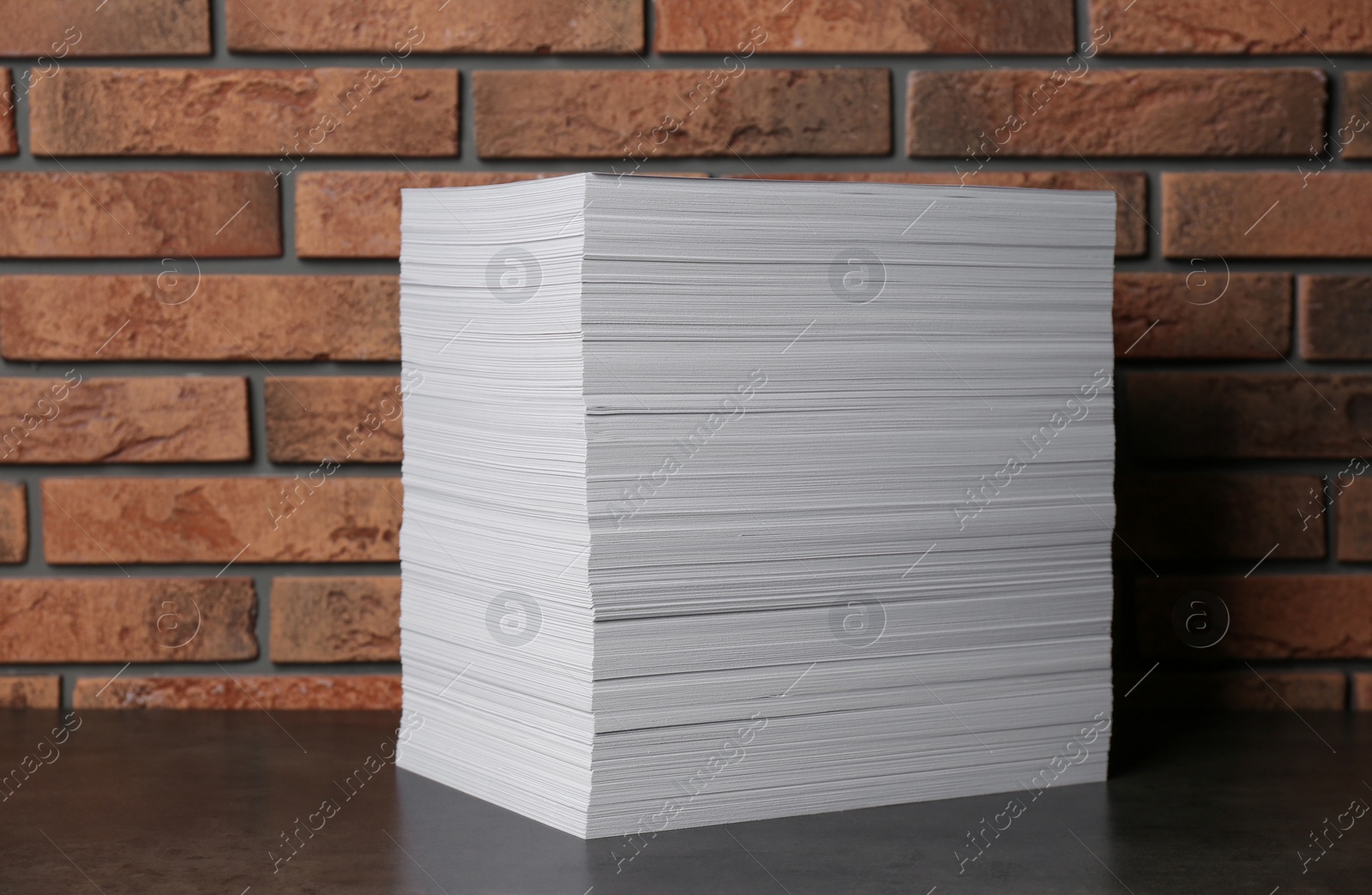 Photo of Stack of paper sheets on black table