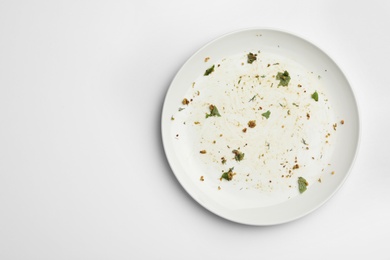 Photo of Dirty plate with food leftovers on white background, top view