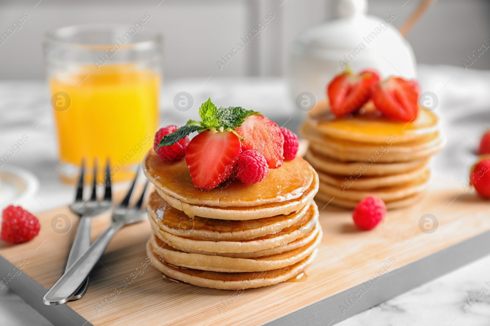 Photo of Tasty pancakes with berries on wooden board