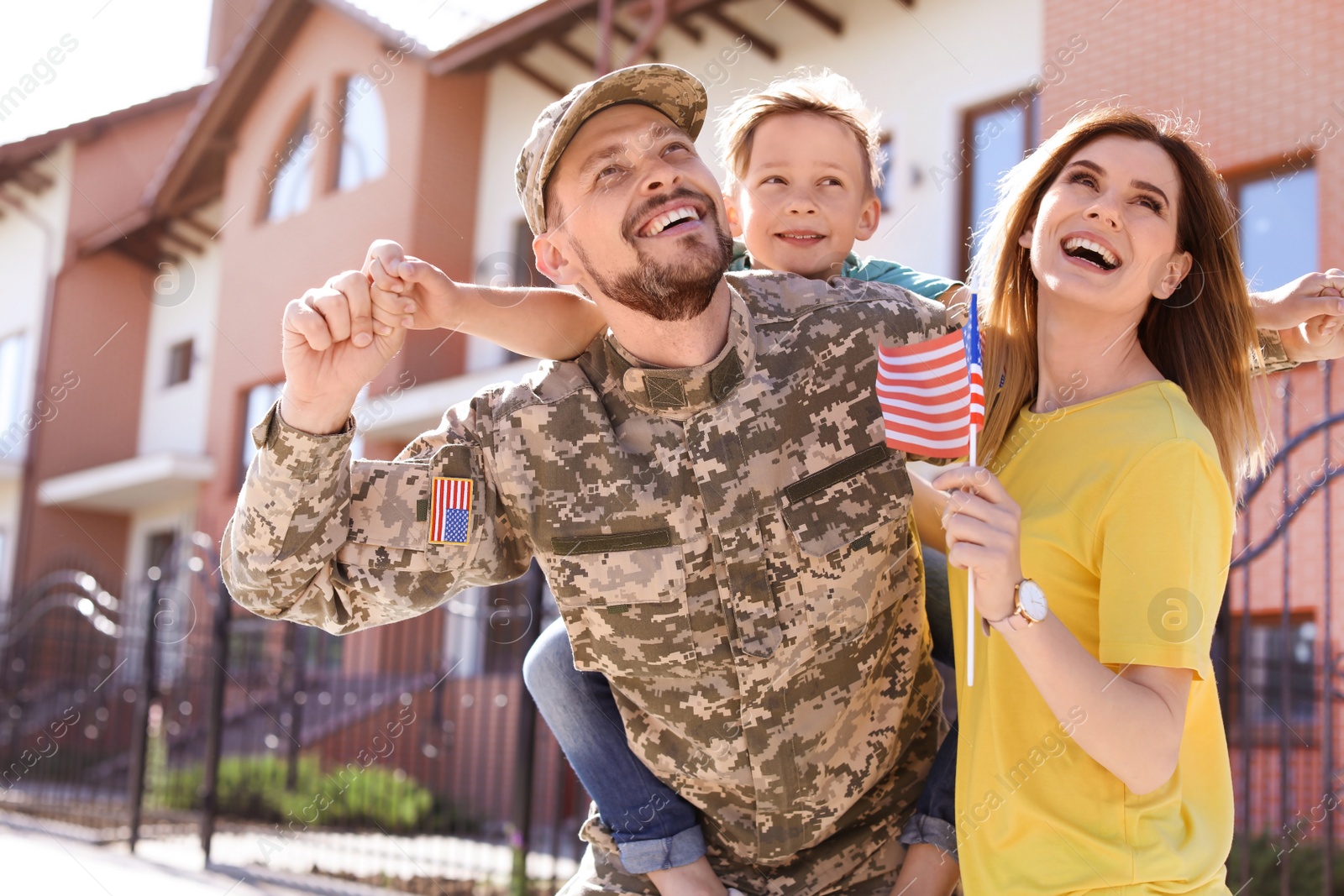 Photo of Male soldier reunited with his family outdoors. Military service