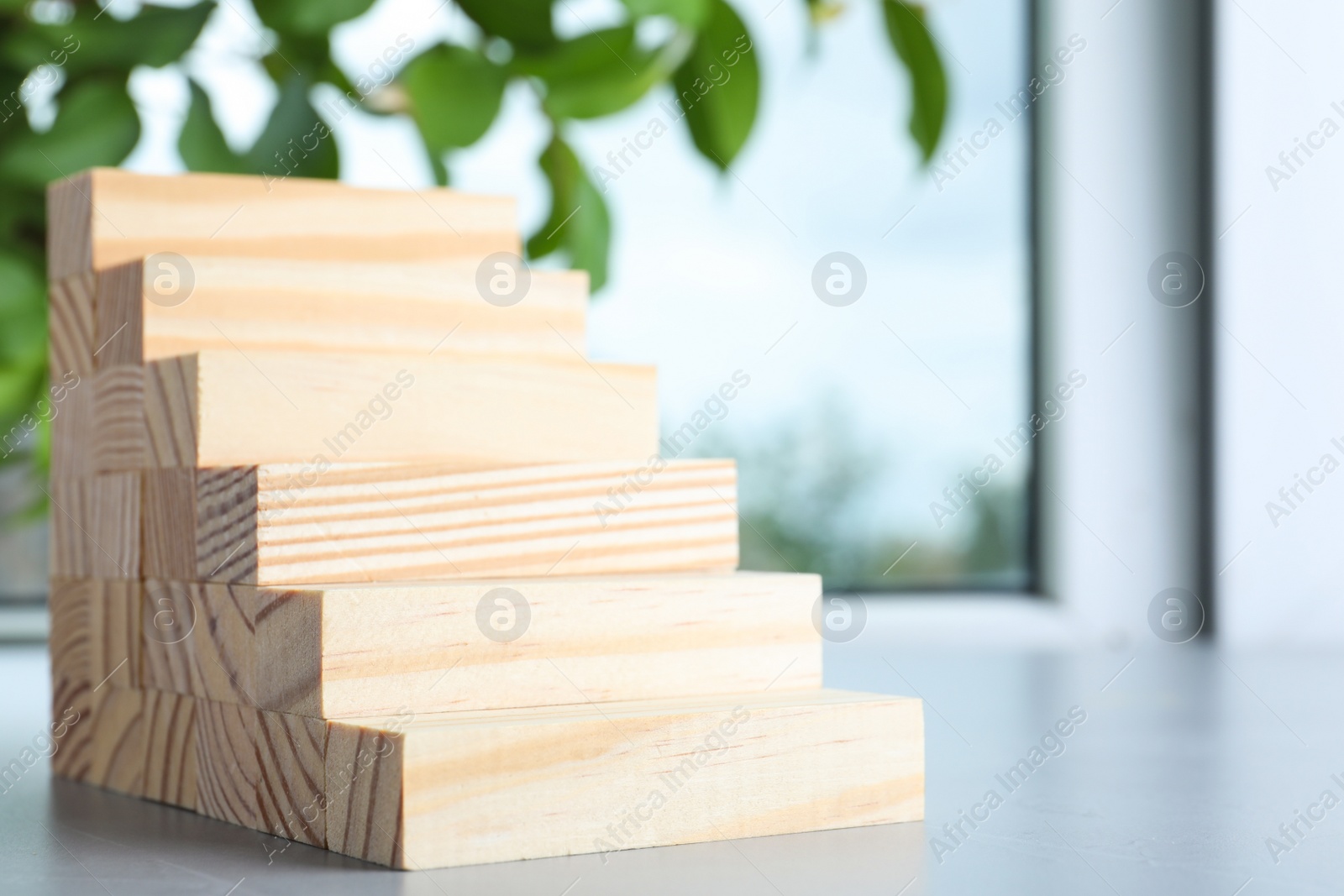 Photo of Steps made with wooden blocks on light grey table indoors, space for text. Career ladder