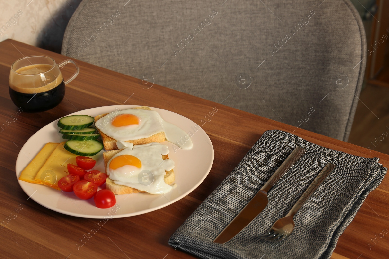 Photo of Tasty toasts with fried eggs, cheese and vegetables on wooden table