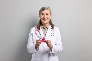 Photo of Mammologist with pink ribbon on gray background. Breast cancer awareness