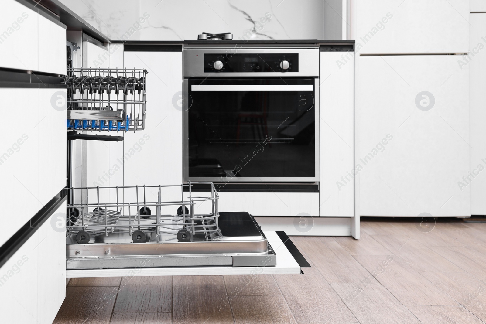 Photo of Open clean empty dishwasher in kitchen. Home appliance