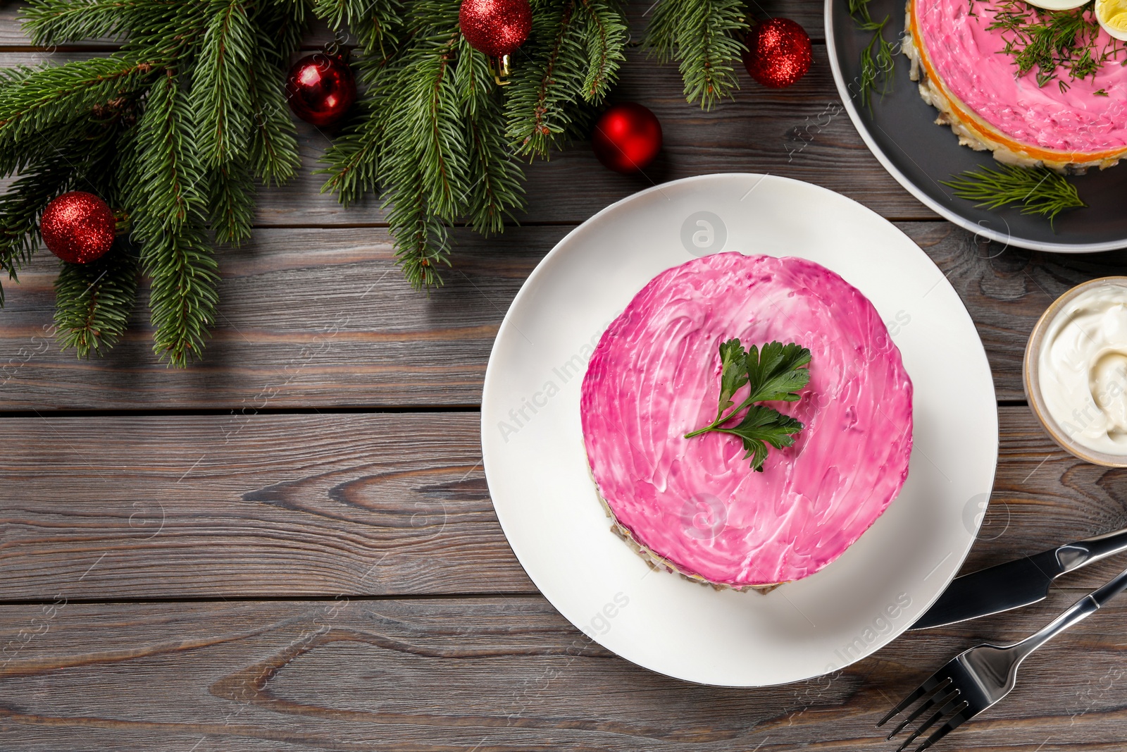 Photo of Herring under fur coat salad and Christmas decor served on wooden table, flat lay with space for text. Traditional Russian dish