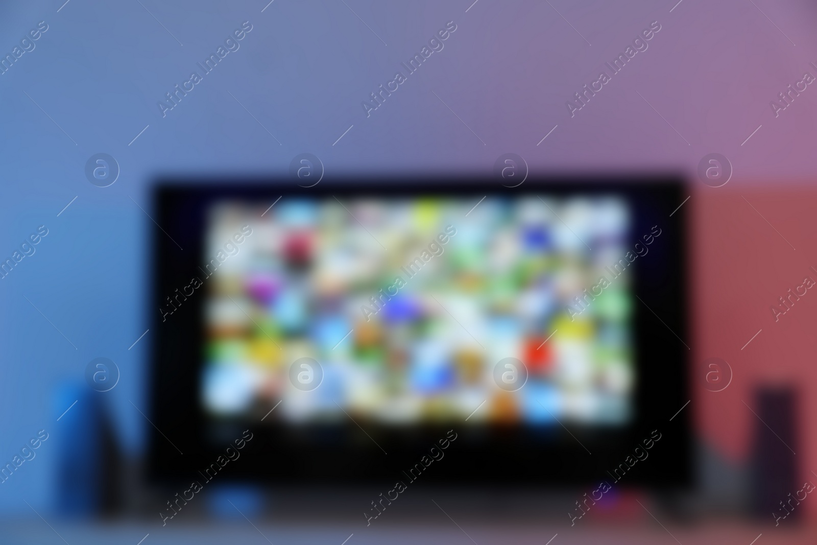 Photo of Blurred view of modern TV set on table indoors