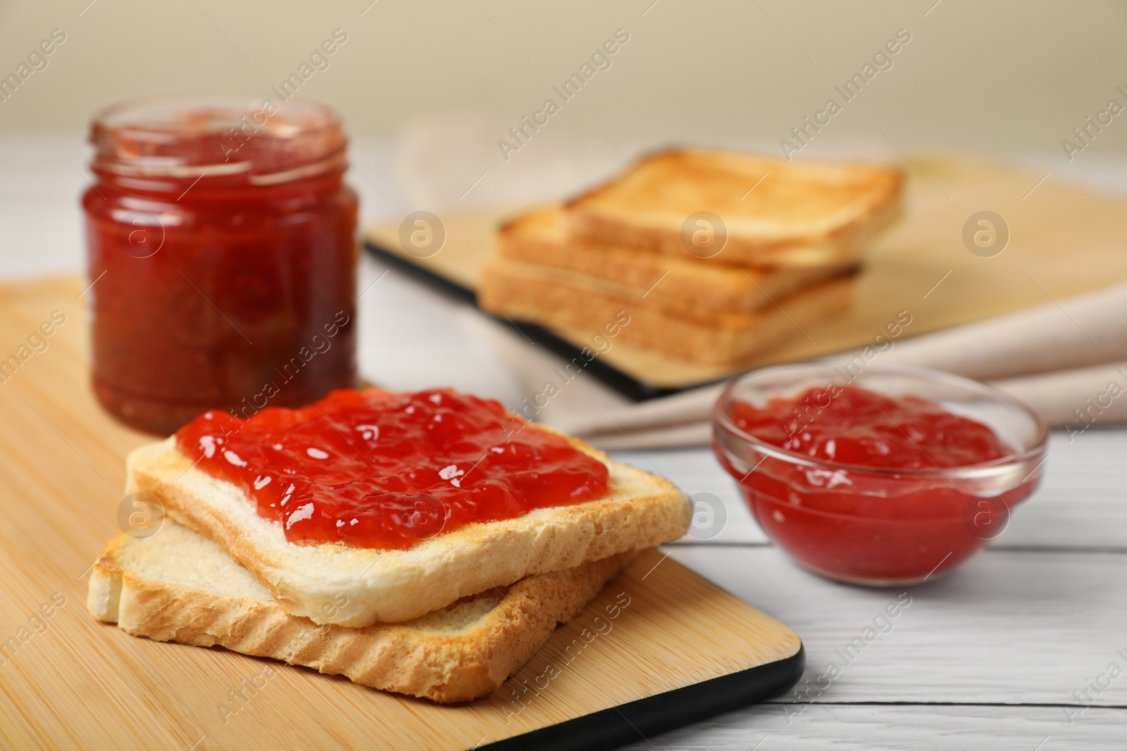 Photo of Fresh toast with delicious blueberry jam on white wooden table, space for text