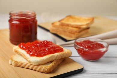 Photo of Fresh toast with delicious blueberry jam on white wooden table, space for text