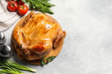 Photo of Tasty roasted chicken with different products on light grey table, flat lay. Space for text