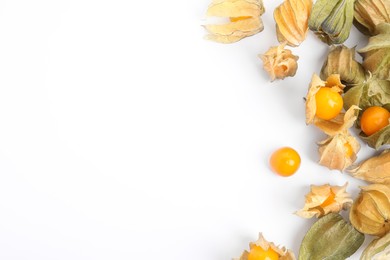 Ripe physalis fruits with dry husk on white background, top view
