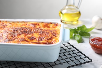 Photo of Tasty cooked lasagna in baking dish on table, closeup