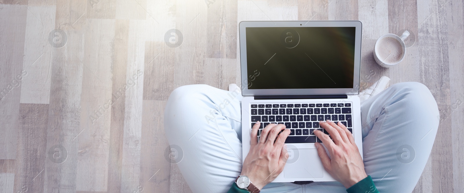 Image of Young man working on computer indoors, top view with space for text. Banner design