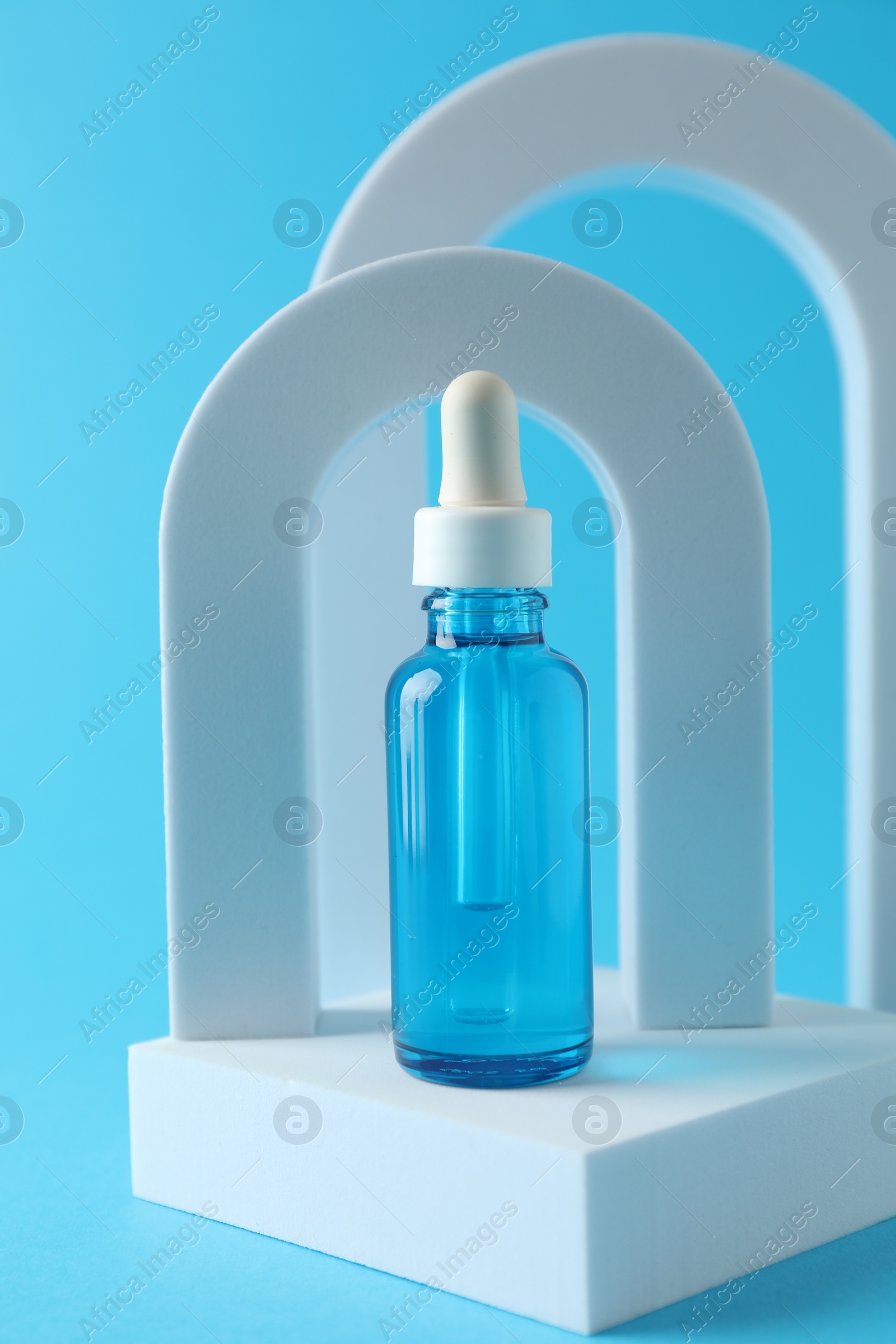 Photo of Stylish presentation of serum on light blue background