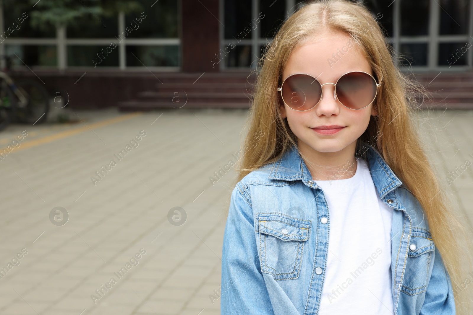 Photo of Girl wearing stylish sunglasses on street, space for text