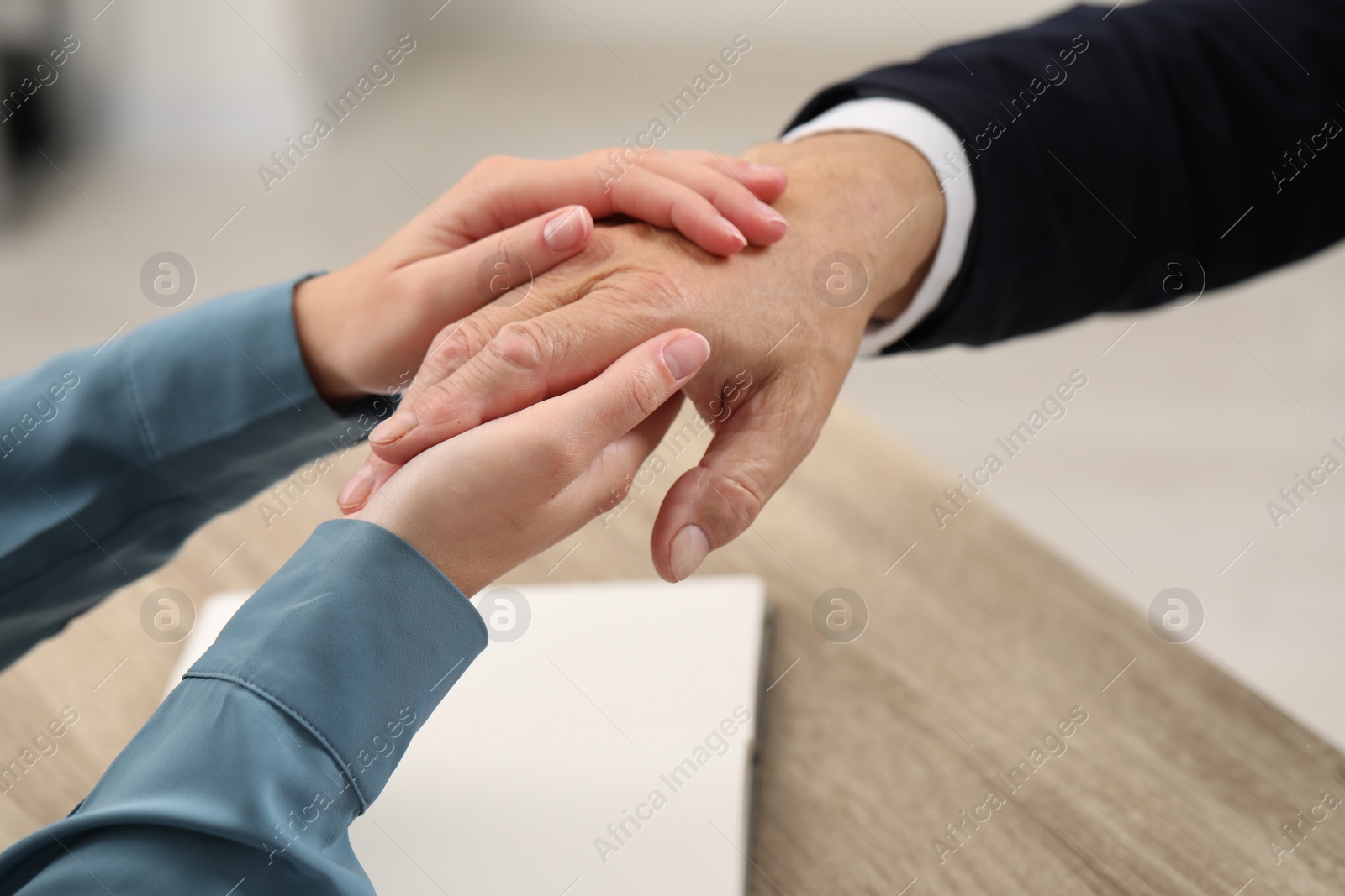 Photo of Trust and deal. Woman with man joining hands indoors, closeup