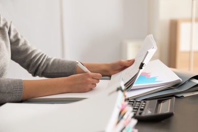 Photo of Office employee working with documents at table, closeup