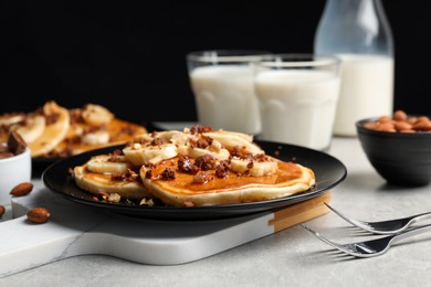 Photo of Tasty pancakes with sliced banana served on light grey table