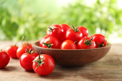 Photo of Bowl of fresh cherry tomatoes on wooden table