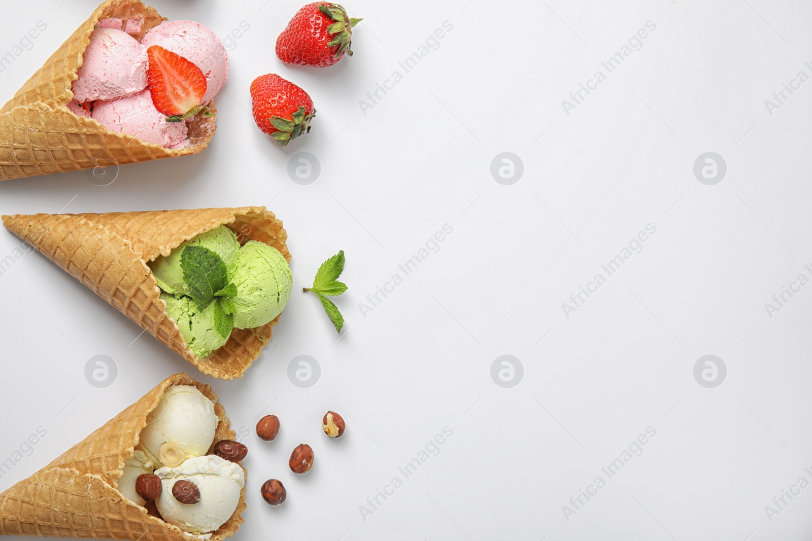 Photo of Composition with delicious ice creams in waffle cones on white background, top view