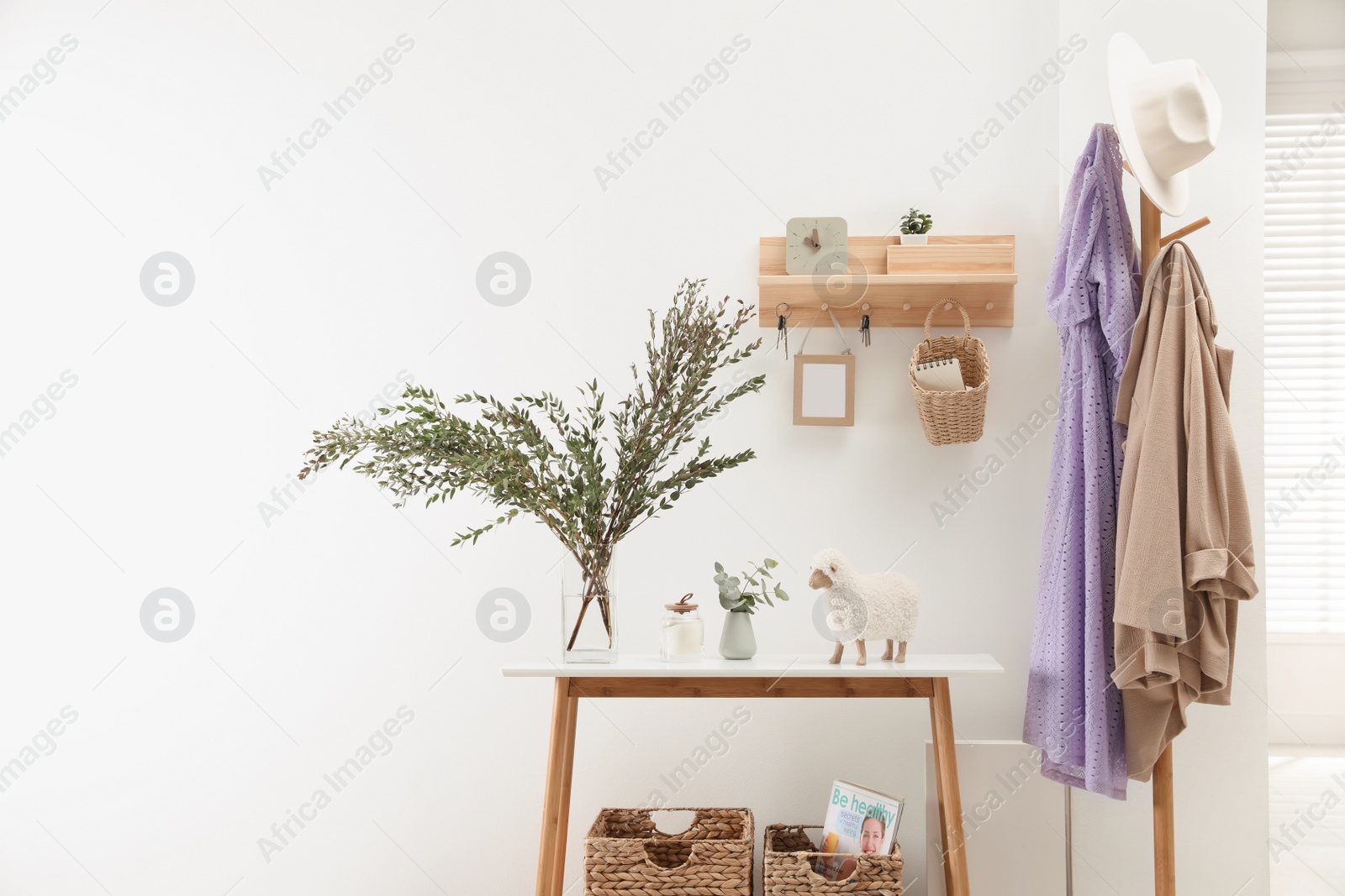 Photo of Wooden clothes rack and key holder on white wall in hallway