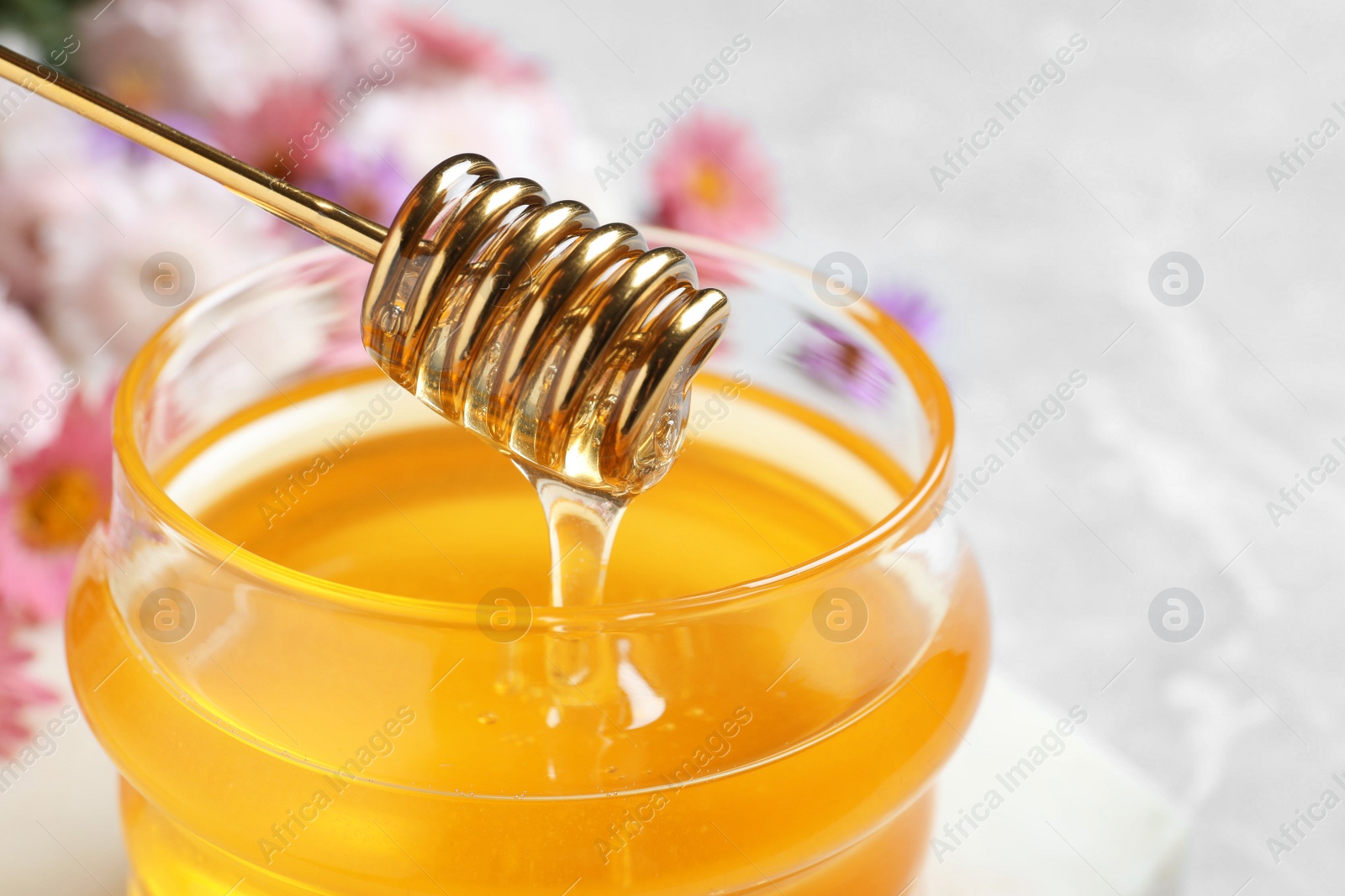 Photo of Jar of organic honey and dipper, closeup